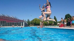 Madrid beaches: young ladies jumping into the water in an outdoor pool